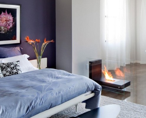 Серое покрывало на кровати возле камина Серое покрывало на кровати возле камина