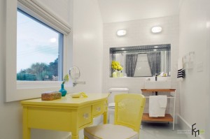 Желтый туалетный столик под окном в ванной