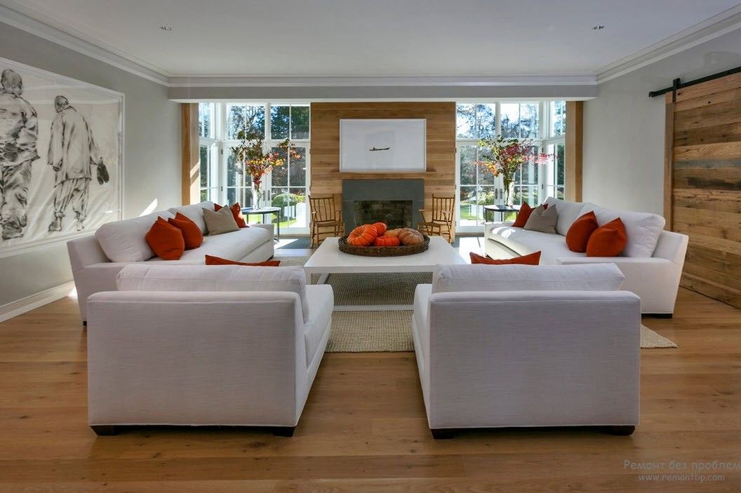 Білі меблі у вітальні з помаранчевим акцентом