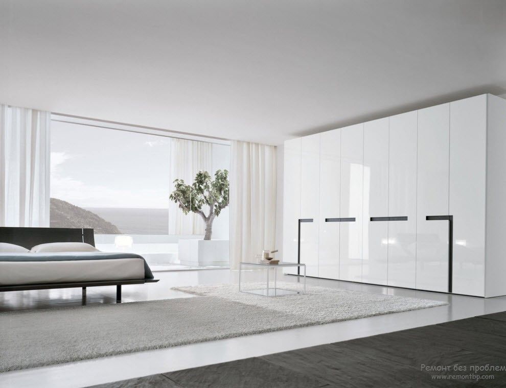 Деревце в интерьере просторной белой спальни в стиле минимализм
