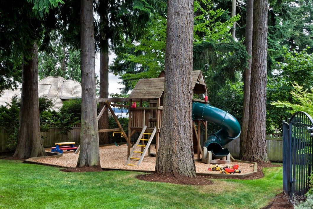 Деревянный детский домик на территории детской площадки