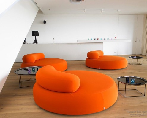 Зона семейного отдыха с ярко-оранжевой круглой мебелью