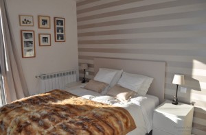 Благородный интерьер спальни с отделкой одной стены горизонтальными полосами
