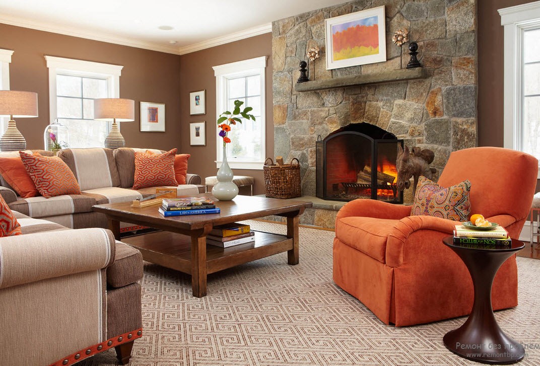 Красное кресло с подущками освежают интерьер коричневой гостиной