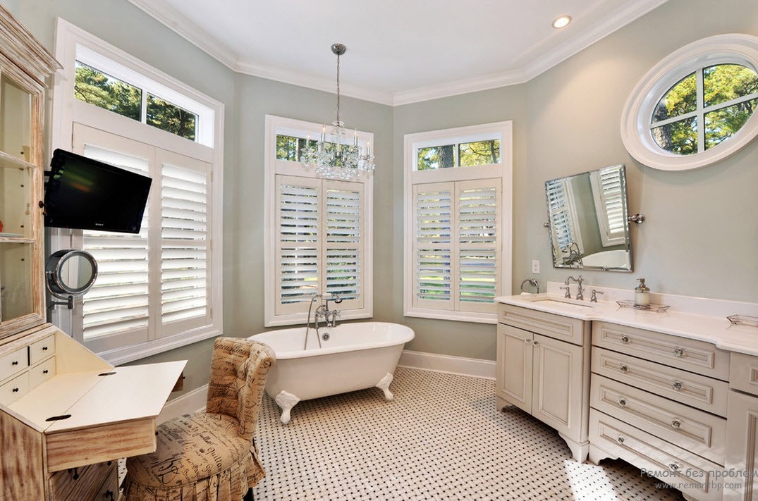 Красива простора ванна кімната у морському стилі з вікном-ілюмінатором.