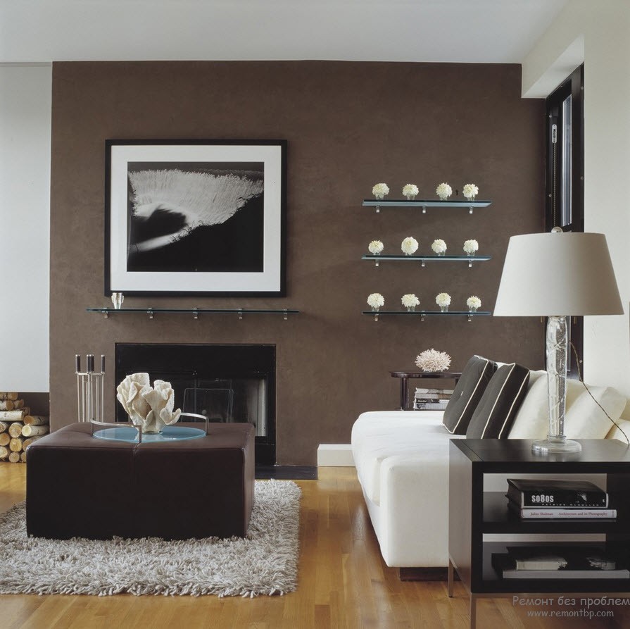 Одна стена гостиной темно-коричневая, на фоне которой светлые аксессуары