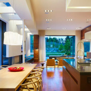 Изящная люстра и точечные светильники по периметру кухонной и гостинной зон