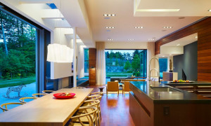 Изящная люстра и точечные светильники по периметру кухонной и гостинной зон
