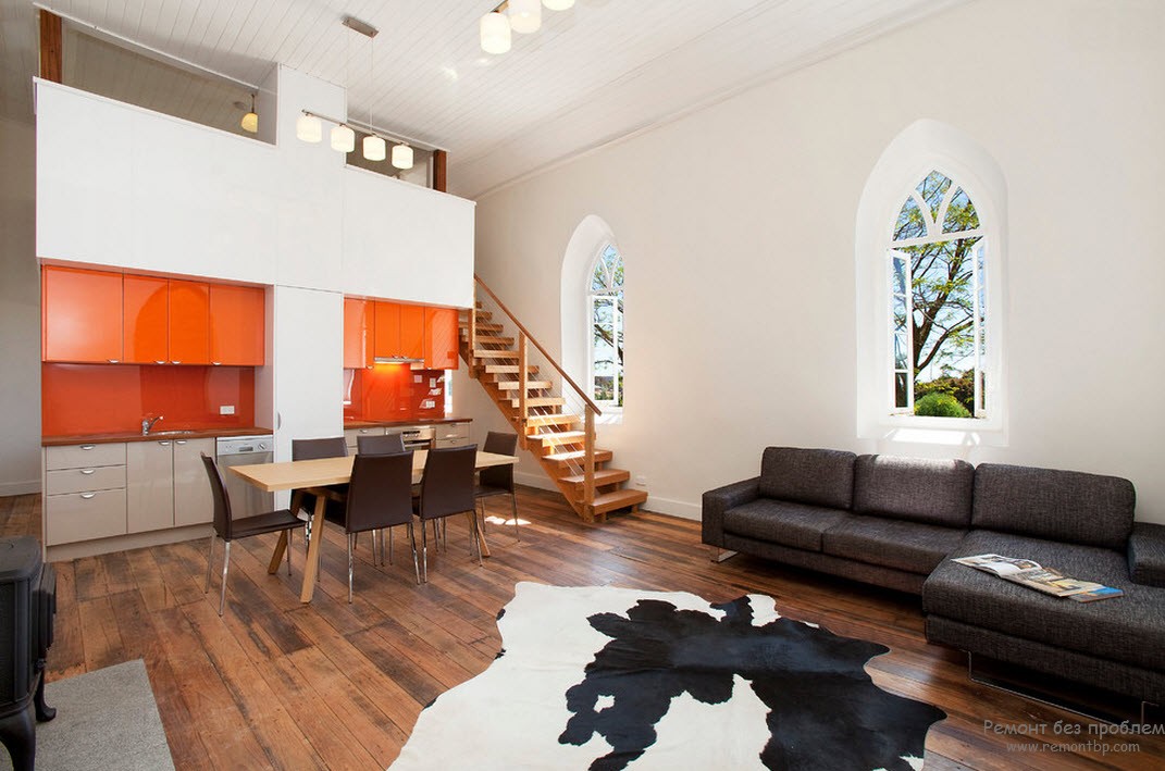 Интерьер оранжево-белой кухни, совмещенный с гостиной