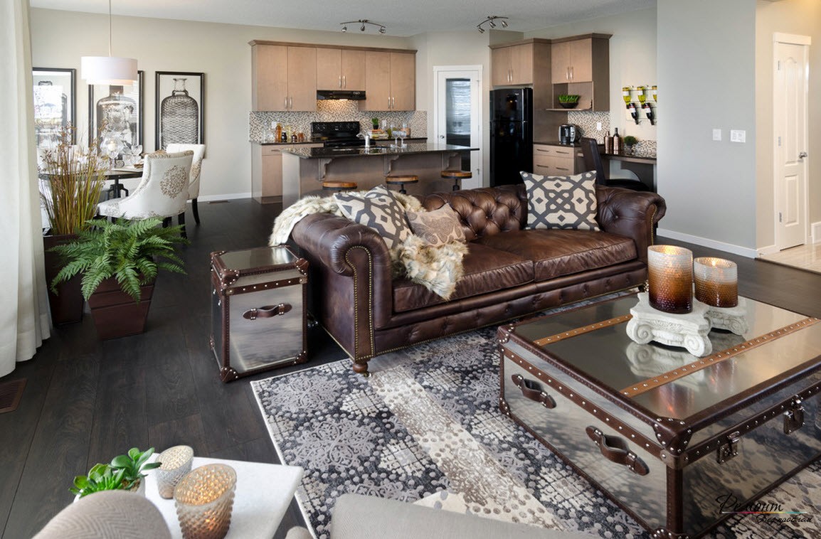 Интерьер просторной загородной гостиной=кухни-столовой с красивым кожаным диваном
