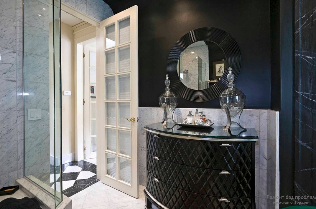 Стеклянная душевая кабина крайне уместна в интерьере черно-белой ванной комнаты небольших размеров