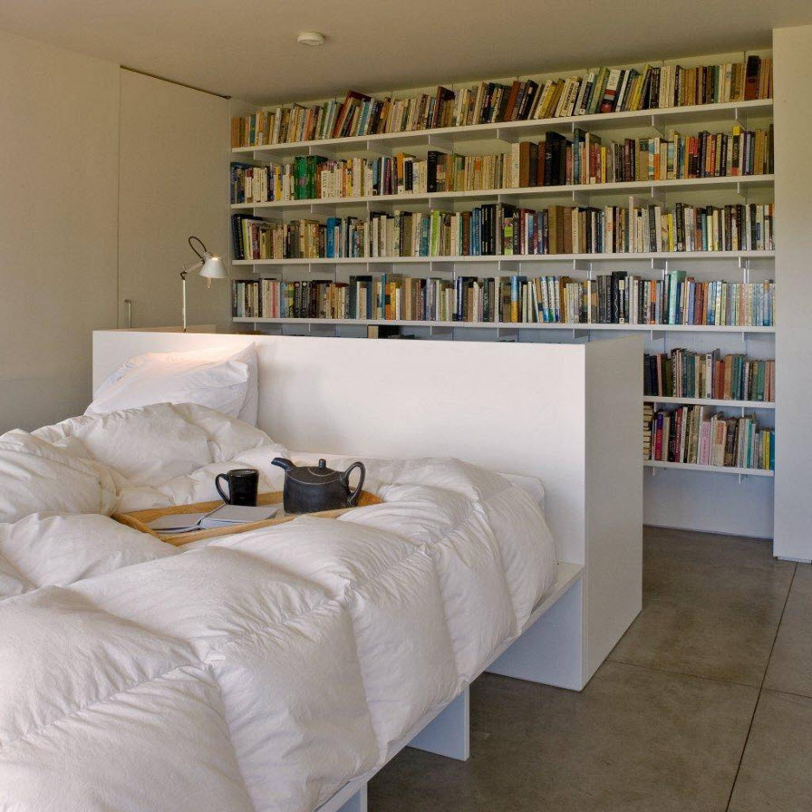 Белые книжные полки в спальне
