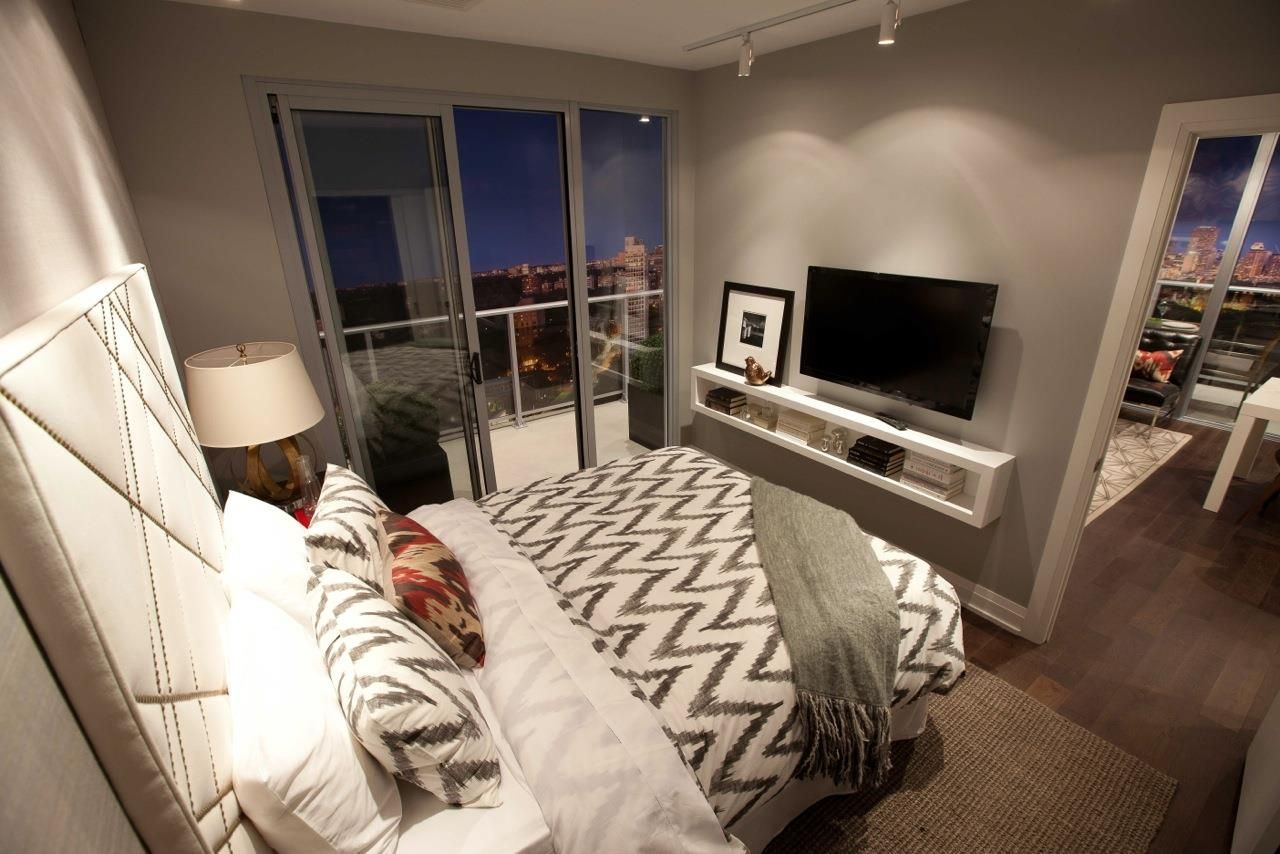 В спальне перед телевизором. Телевизор в маленькой спальне. Телевизор в спальне на стене. Уютная спальня с телевизором. Комната с кроватью.