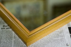 Угол деревянной рамы для зеркала на газете