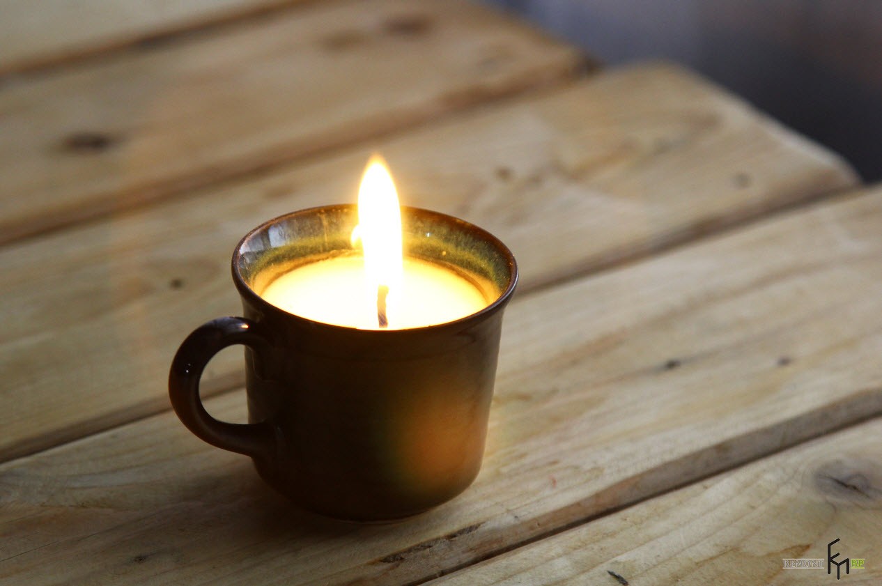 Зажженная свеча в чашке